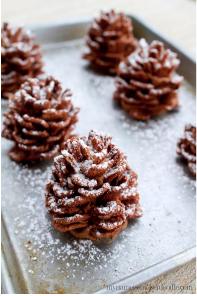 Edible Chocolate Pinecones are such a holiday delight!  This no bake dessert recipe can be made ahead and only takes 30 minutes to create.  A creamy center made of peanut butter and chocolate spread and would you believe the outside is made of cereal?!  Imagine these on your Christmas dessert board or bringing them to your holiday party!