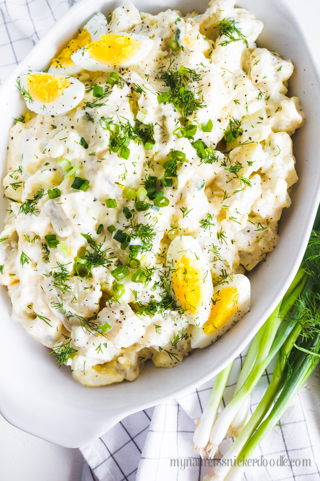 Creamy Potato Salad with eggs and scallions in a oval dish.