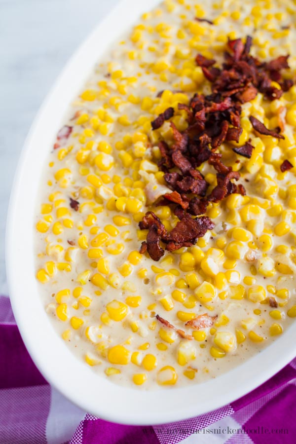 Creamed Corn With crumbled bacon in a white bowl