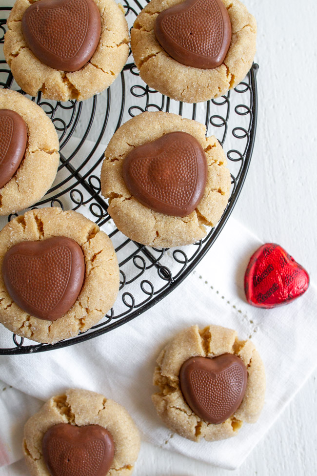 Peanut Butter Blossom with a chocolate heart on a black wire cooling rack