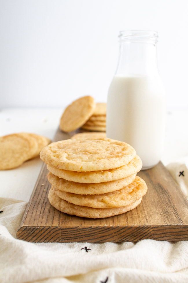 Snickerdoodle Cookies on a wooden tray with a glass of milk.