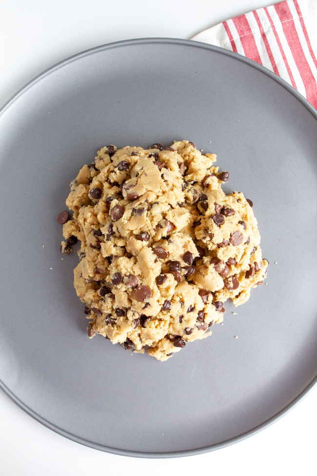 Chocolate Chip Cookie Dough in a pile on a silver pizza pan.