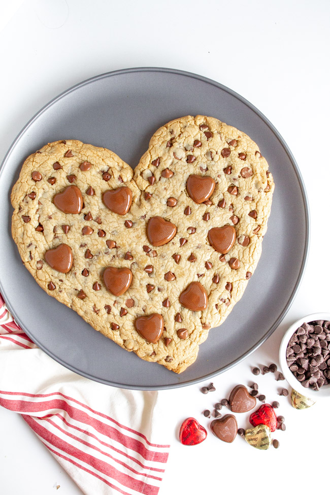 Heart Shaped Chocolate Chip Cookie with heart chocolates on a pizza pan.