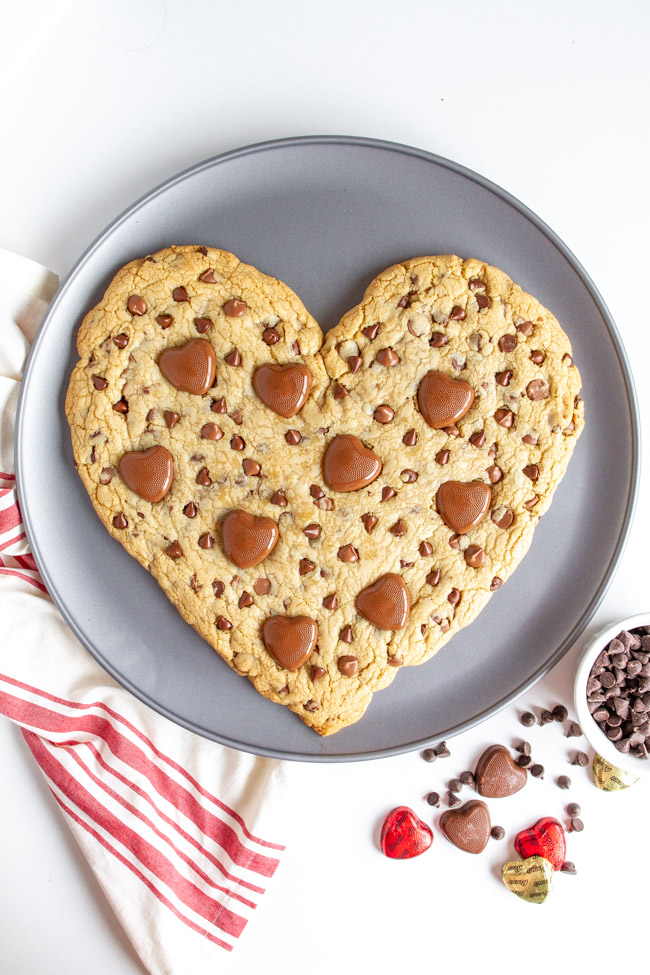 Heart Shaped Chocolate Chip Cookie with heart chocolates on a pizza pan.