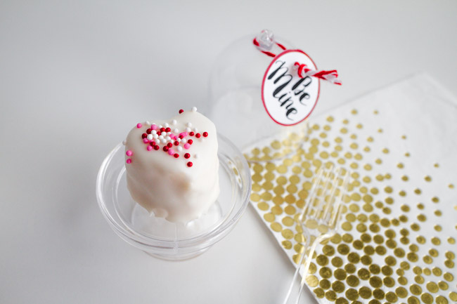 White small heart cake on a tiny cake pedestal.