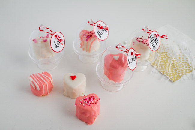 Mini pink and white heart cakes with sprinkles on tiny cake stands