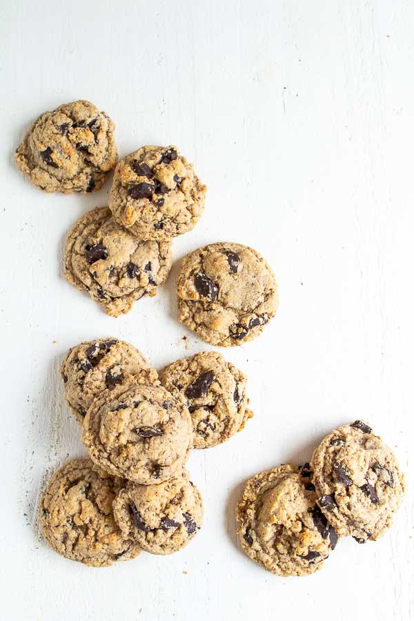A dozen Oatmeal Chocolate Chip cookies laying on a white table.  