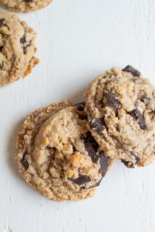 Two cookies laying on a white table.  