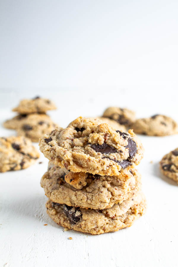 Oatmeal Chocolate Chip cookies stacked up on a white table.  