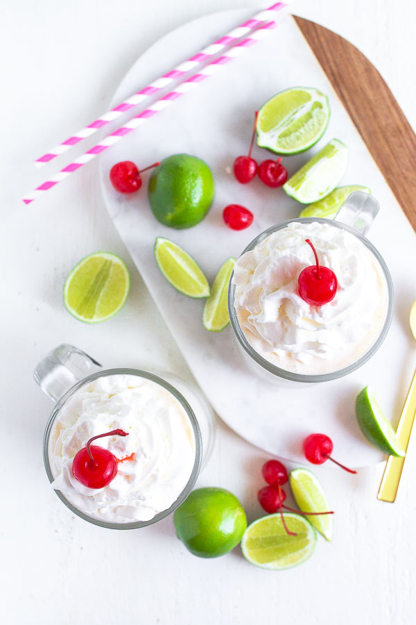 Two mugs with Frozen Key Lime and topped with whipped cream and cherries.  