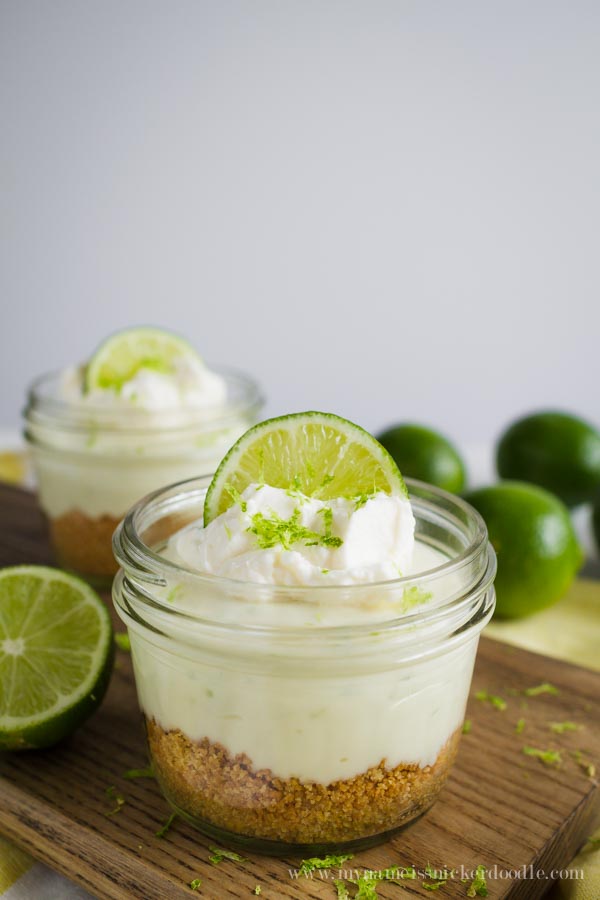 Mini Key Lime No Bake Cheesecakes in a small mason jar with whipped cream and a lime wedge.