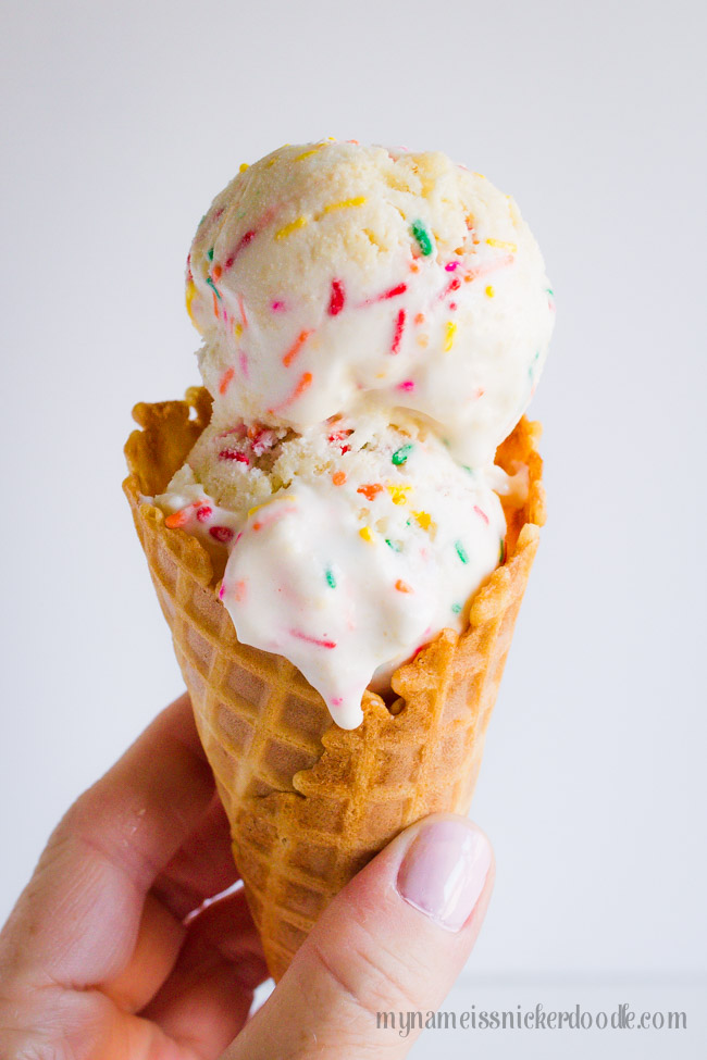 Waffle cone with two scoops of birthday cake ice cream.