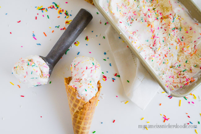 A scoop of birthday cake ice cream and a waffle cone with two scoops.