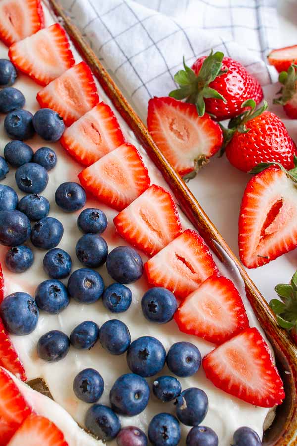 A spatula serving a square of fruit pizza.  