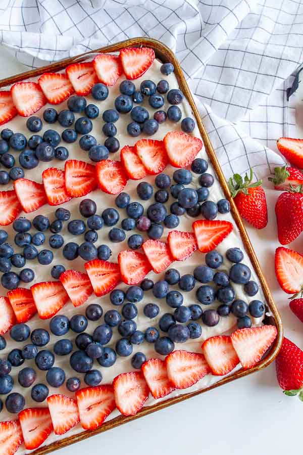 Fruit Pizza with strawberries and blueberries in a cookie sheet.