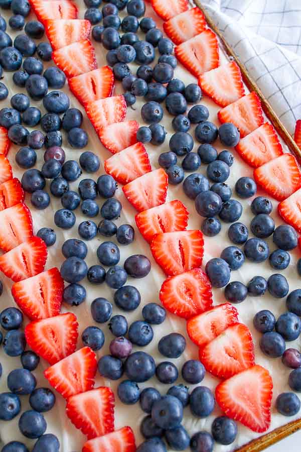 A close up shot of a Flag Dessert with strawberries and blueberries in a cookie sheet.