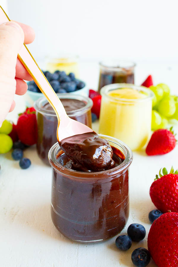 A spoon full of Betty Crocker Chilled Treats on a white table with fruit.