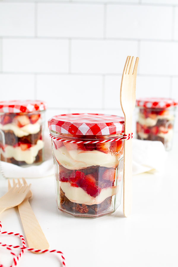 Brownie Strawberry Trifle in mini jam jars.  Layered with brownies, fresh strawberries and cream cheese frosting.  