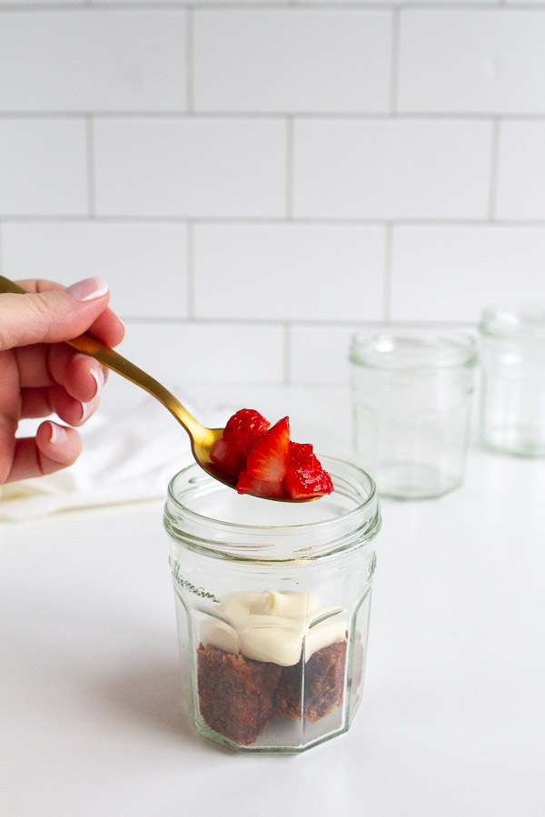 Brownie Strawberry Trifle in mini jam jars.  Layered with brownies, fresh strawberries and cream cheese frosting.  