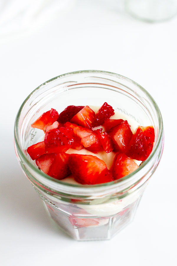 Brownie Strawberry Trifle in mini jam jars.  Layered with brownies, fresh strawberries and cream cheese frosting.  