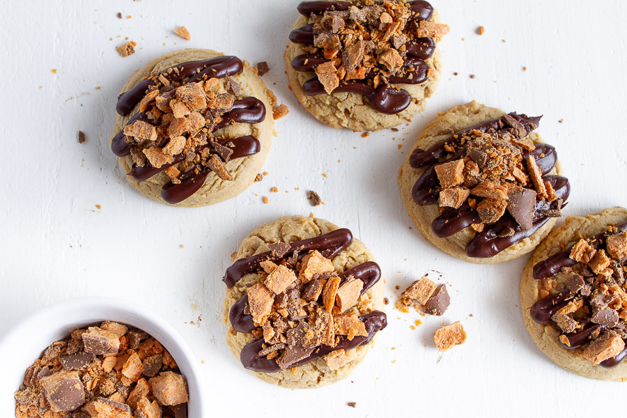 Butterfinger Peanut Butter Cookies are made with a tender chewy peanut butter cookie, drizzled with chocolate and topped with crushed Butterfinger candy!  