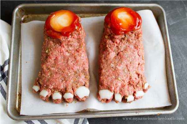 Halloween Feet Loaf a meat loaf recipe with onion toe nails baked on a  a baking sheet.