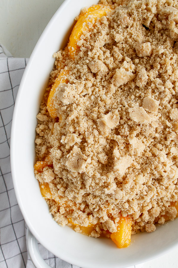 Peach Crisp Recipe served in a white baking dish.  