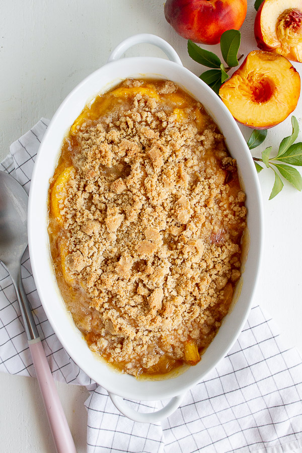 Peach Crisp Recipe served in a white baking dish.  