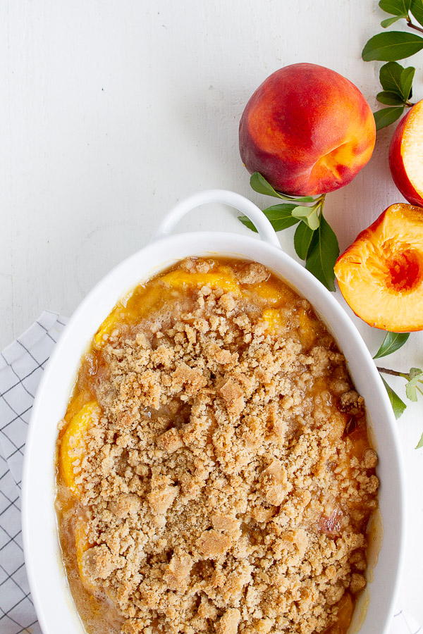 Peach Crisp Recipe served in a white baking dish.  