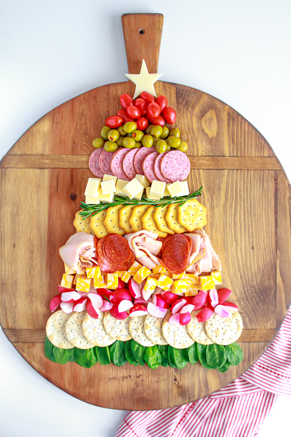 The Ultimate Holiday Appetizer! A Christmas Tree Cheese and Cracker Tray would be great for any holiday party. Full of meats, cheeses, crackers and vegetables. The easiest charcuterie board to assemble! #charcuterie #holidayappetizer #mynameissnickerdoodle #cheeseandcrackers #partyfood #christmasappetizers #easyappetizers #appetizerrecipes #christmasrecipes
