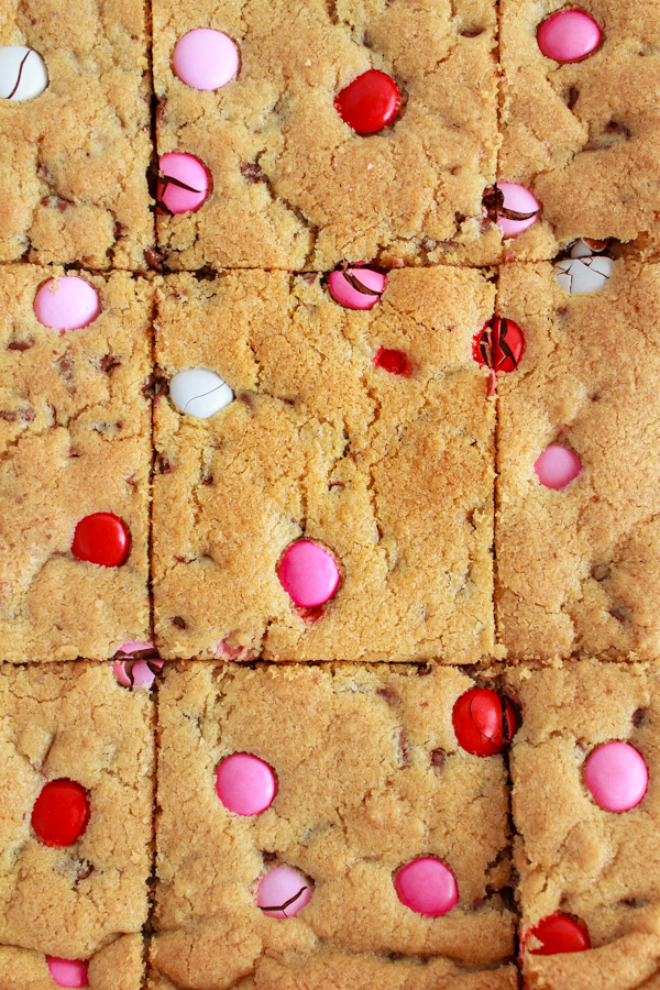 Valentine Chocolate Chip Cookie Bars with pink and red candies.