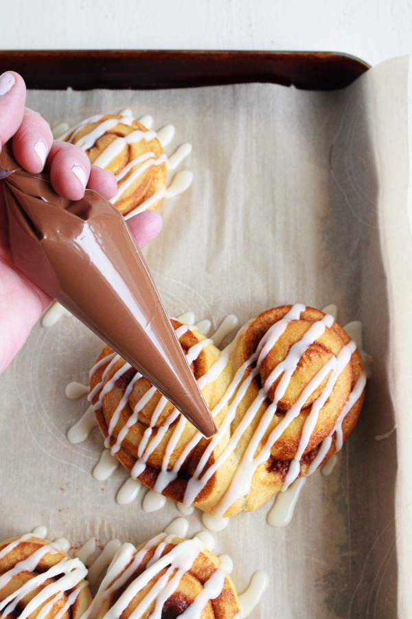 Cinnamon Rolls drizzled with melted chocolate.