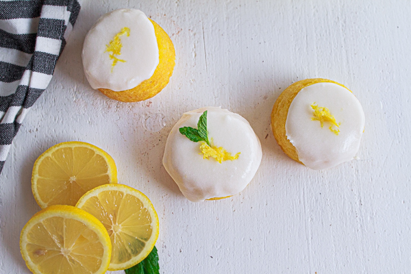 Lemon cakes garnished with lemon zest and mint leaves.