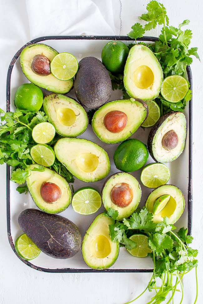 Ripe avocados, cilantro and limes.