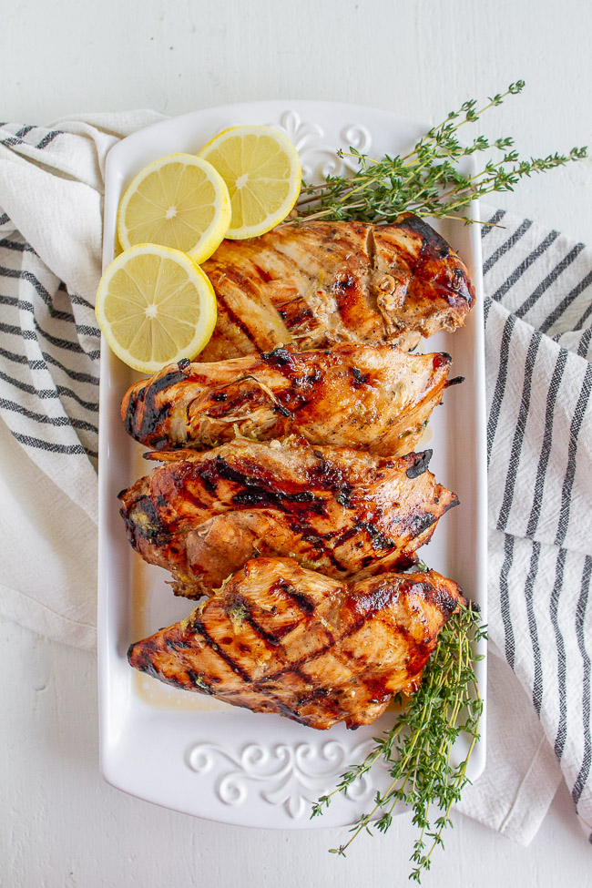 Grilled Chicken with Lemon slices on a white plate.