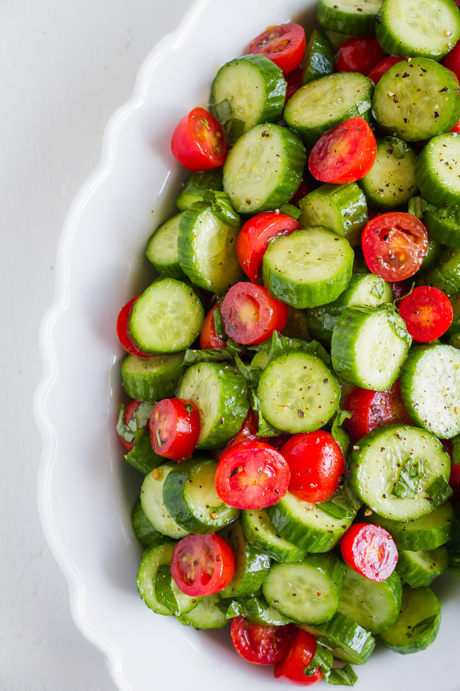 Fresh tomatoes and cucumbers sliced and placed in a white dish.