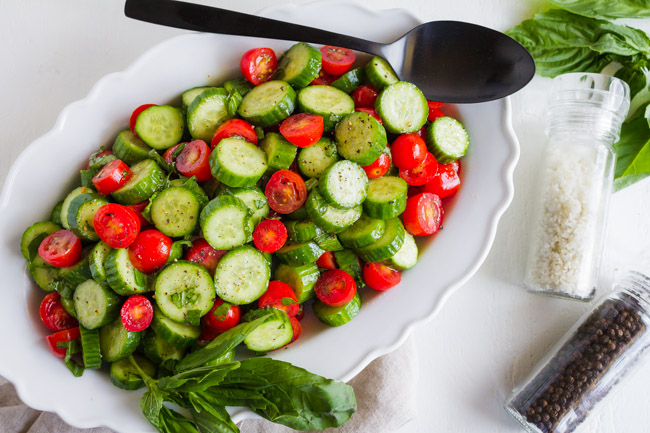 Tomato cucumber salad on a white dish.