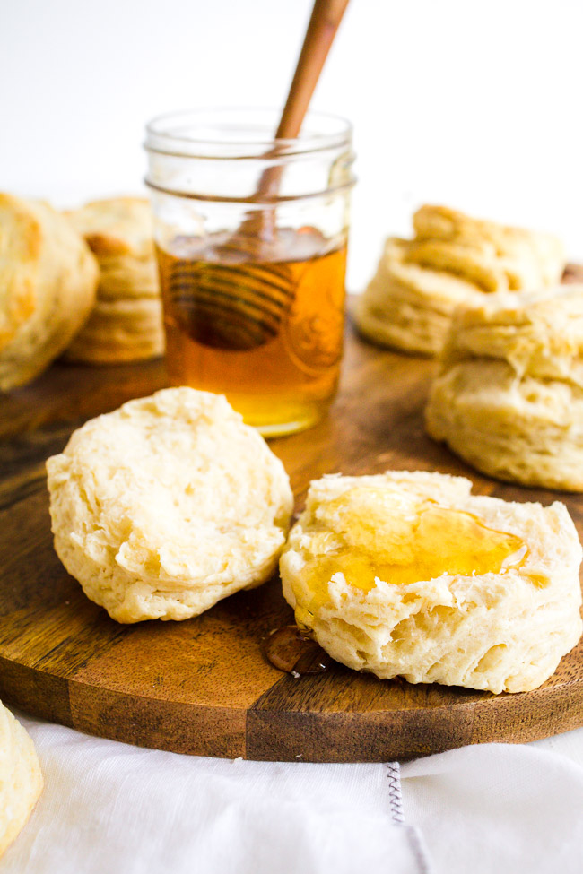 Homemade Flaky Buttermilk Biscuits drizzled with honey.