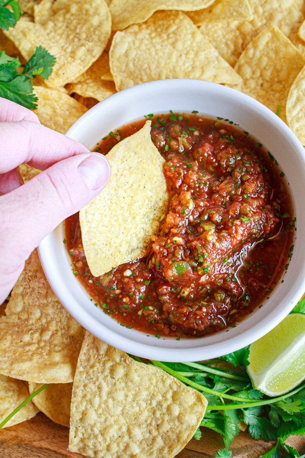 Dipping a tortilla chip into 5 minute salsa.