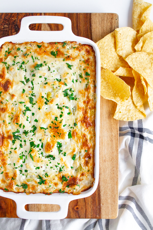 A white dish full of Cheesy Artichoke Dip