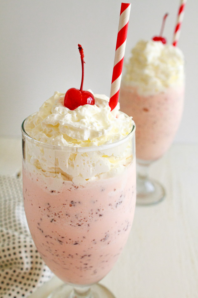 Two Peppermint Chip Milkshakes with whipped cream and a cherry on top. 