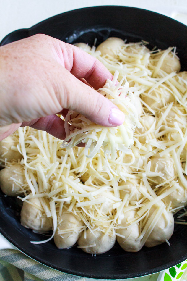 Sprinkling cheese over bread dough