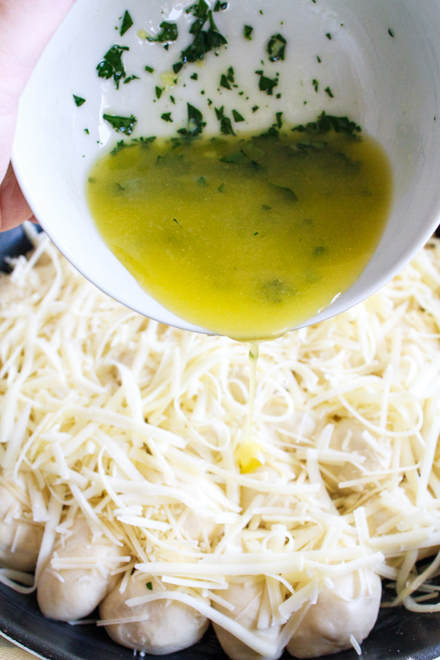 Parsley Garlic Butter being poured over cheese bread