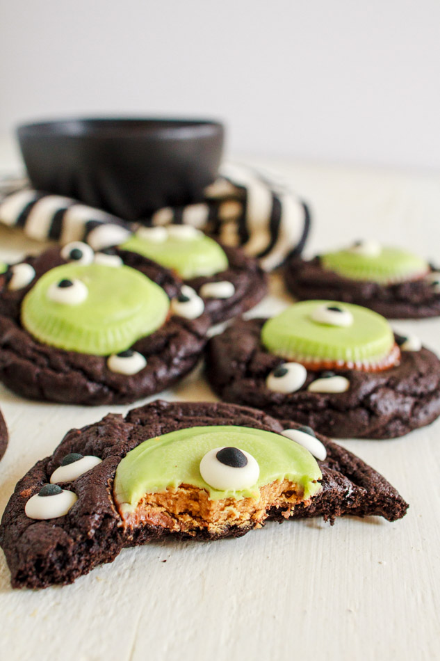 Halloween Monster Cookies are a fun and spooky treat.  Fudgey cookies full of chocolate flavor and black coco powder.  They are then embellished with Googley Candy Eyes and finished off with a Reese's Peanut Butter Franken Cup.  