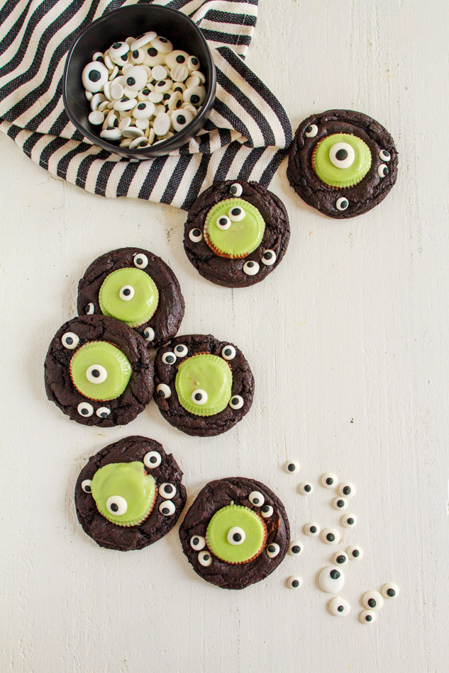 Halloween Monster Cookies are a fun and spooky treat.  Fudgey cookies full of chocolate flavor and black coco powder.  They are then embellished with Googley Candy Eyes and finished off with a Reese's Peanut Butter Franken Cup.  