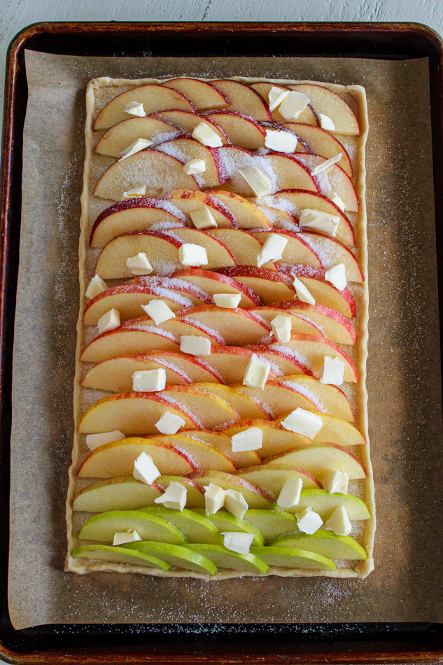 This Apple Tart is super simple to make!  Arrange an ombre array of apples, darkest to lightest, on a homemade pasty dough and baked to perfection.  Sweet and tart all on a flaky crust!  No pie plate is needed.  Super simple recipe and perfect for the holidays!